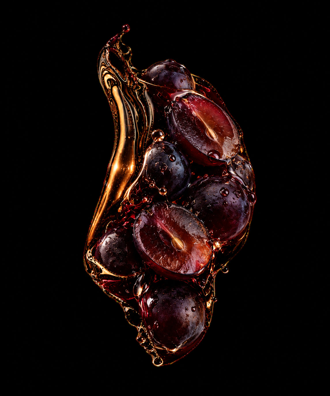 Dark grapes caught in a splash of golden wine